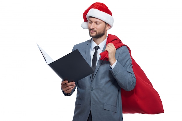 Studioporträt des Mannes wie Weihnachtsmann mit voller Tasche mit Geschenken