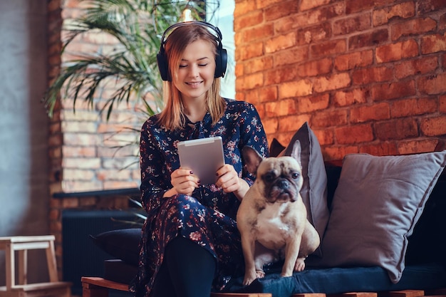 Studioporträt einer attraktiven, fröhlichen Blondine in einem Raum mit Loft-Interieur.