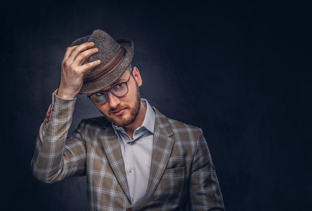 Studioporträt eines bärtigen Hipsters mit Hut und Brille