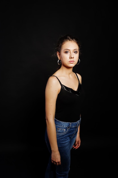 Studioporträt eines brünetten Mädchens mit Make-up auf schwarzem Hintergrund
