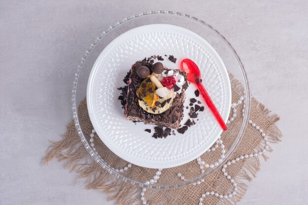 Stück Schokoladenkuchen auf weißem Teller mit Perlen.