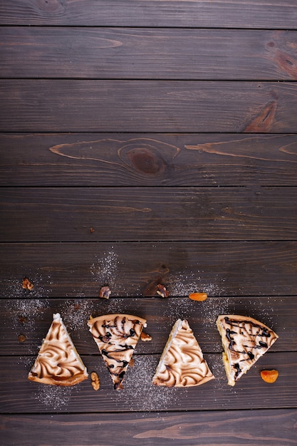 Stück Zitronenkäsekuchen mit weißer Creme diente auf einem dunklen Holztisch