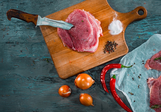 Stücke rohes Schweinefleischsteak mit Gewürzen und Krautrosmarin