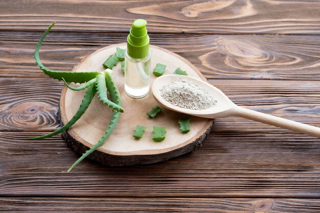 Stücke von Aloe Vera Blätter auf Holzachterbahn und Gel