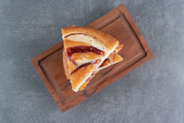 Stücke von Obstkuchen auf einem hölzernen Schneidebrett