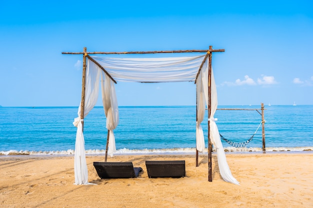 Stuhl Sonnenschirm und Lounge am schönen Strand Meer Ozean am Himmel