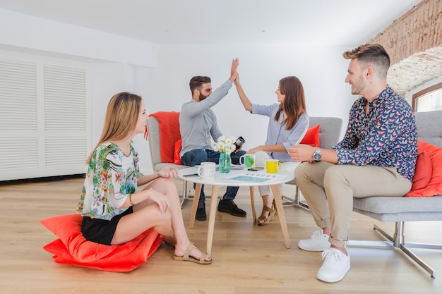 Stylische Kollegen am Tisch trinken Kaffee