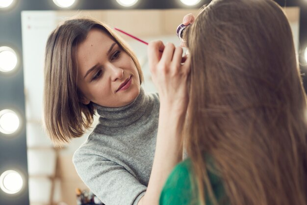 Stylist, der Eyeliner auf anonymem Modell verwendet