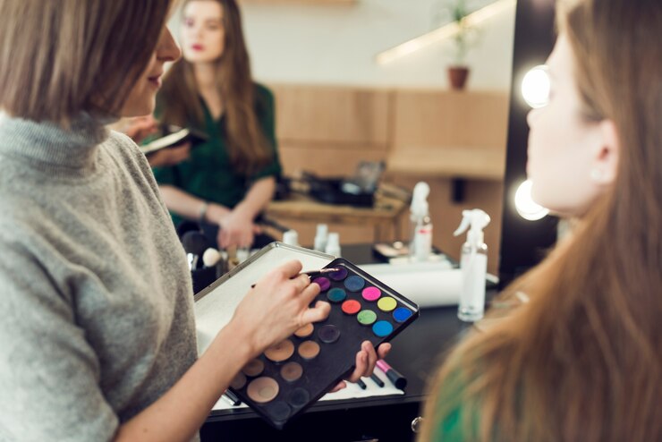 Kostenlose Foto stylist, der lidschatten von der palette auswählt