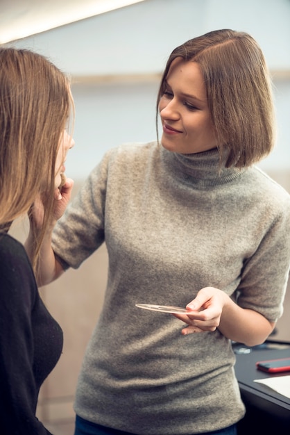 Stylist, der Make-up auf gesichtslosem Modell anwendet