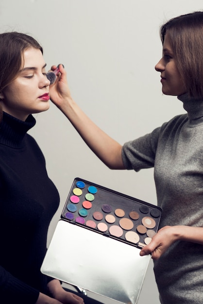 Kostenloses Foto stylist mit pallete, das mit modell arbeitet