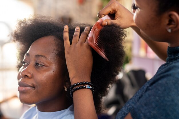 Stylistin, die sich um ihr Afro-Haar kümmert