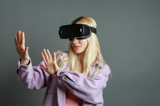 Kostenloses Foto süße blondine trägt eine vr-brille und hält ihre hände offen