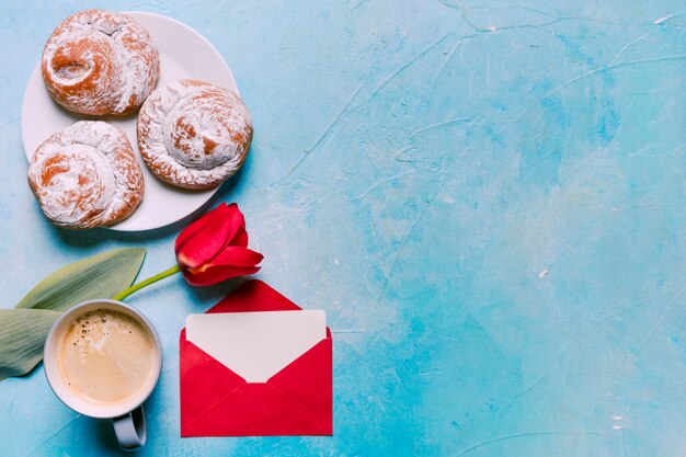 Süße Brötchen auf Platte mit roter Tulpe