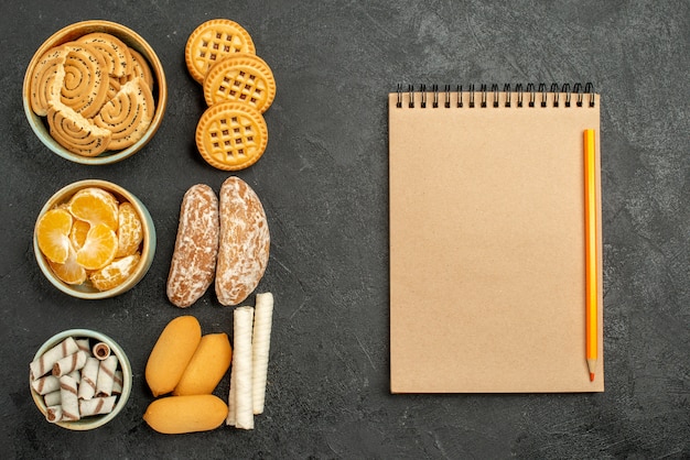 Kostenloses Foto süße kekse der draufsicht mit keksen und früchten auf einem grauen schreibtisch