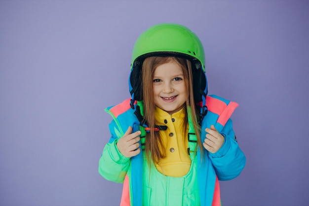Süße kleine Mädchen tragen Skibekleidung isoliert im Studio