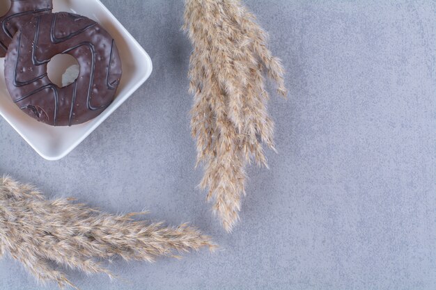 Süße leckere Schokoladenkrapfen auf weißen Tellern.