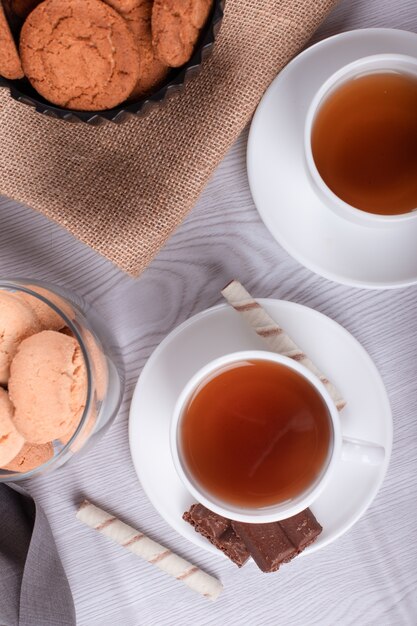 Süße Snacks, Tasse Tee auf hellem Hintergrund