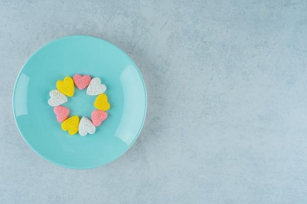 Süße Süßigkeiten Valentinstag Herzen in einer blauen Platte auf weißer Oberfläche