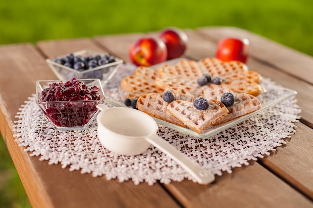 Süße waffel mit früchten im sommertag auf holztisch