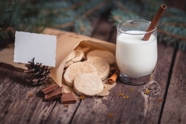 Süße Weihnachtsplätzchen mit Milch auf hölzernen Schreibtischen