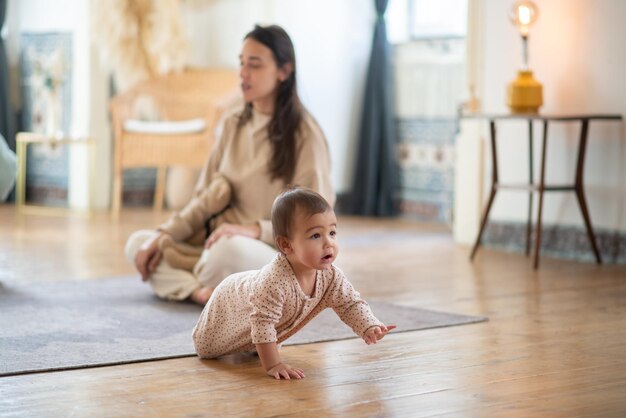 Süßer kleiner Junge, der von seiner Mutter ins Zimmer kriecht