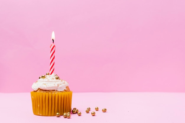 Süßer kleiner Kuchen mit brennender Kerze auf ihr