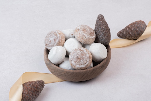 Süßer Lebkuchen mit Tannenzapfen auf Holzplatte.