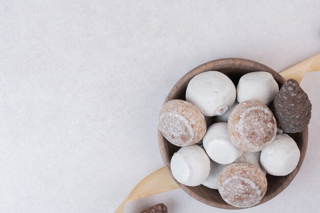 Süßer Lebkuchen mit Tannenzapfen auf Holzteller.