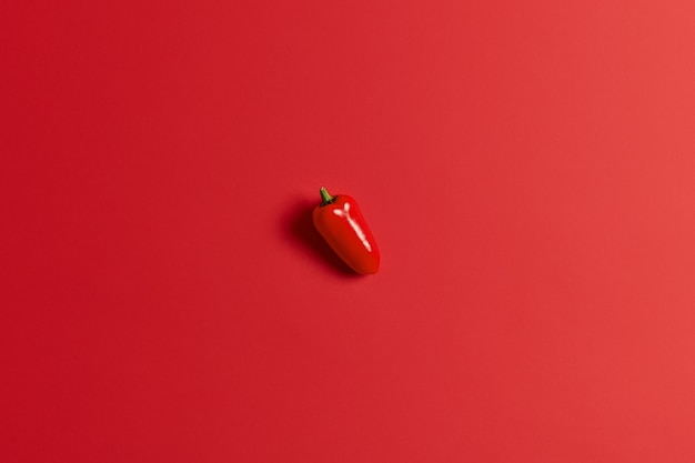 Süßer saftiger roter Paprika lokalisiert über hellem Hintergrund. Paprika für die Zubereitung von leckerem Salat. Gesundes Essen und frisches Gemüse. Nahaufnahme und Draufsicht. Einzelgemüse. Herbsternte.
