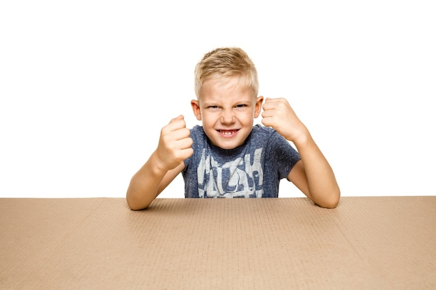 Süßer und verärgerter kleiner Junge, der das größte Postpaket öffnet