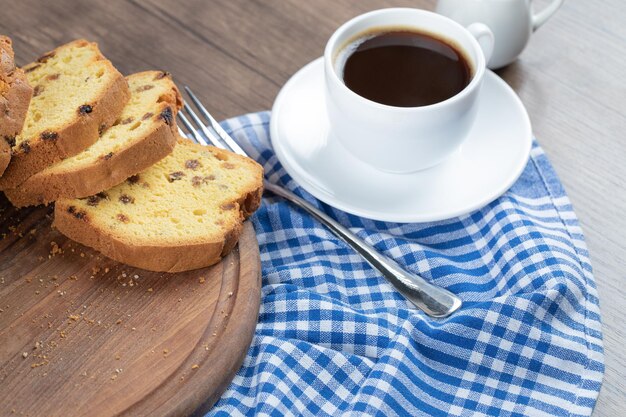 Süßer weicher Kuchen serviert mit einer Tasse Kaffee.