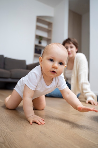 Süßes Baby im niedrigen Winkel, das auf dem Boden kriecht