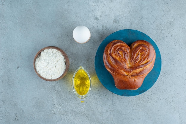 Süßes Gebäck, Mehl und Olivenöl auf Marmoroberfläche.