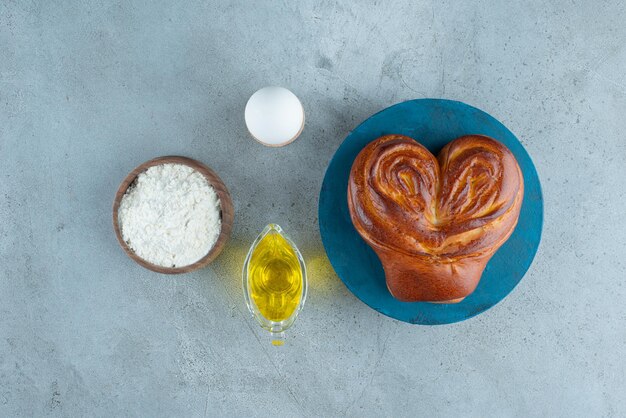 Süßes Gebäck, Mehl und Olivenöl auf Marmoroberfläche.