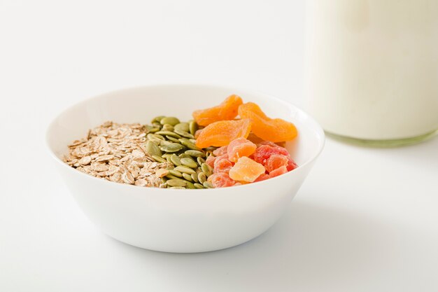 Süßes gesundes muesli mit Milch über dem weißen Hintergrund