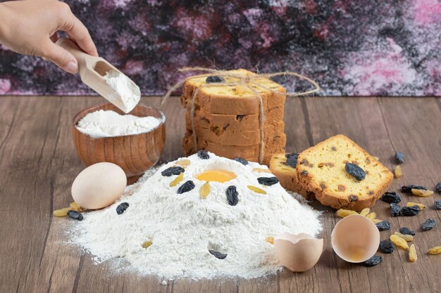 Sultaninenkuchen mit Zutaten auf Holzdeck.