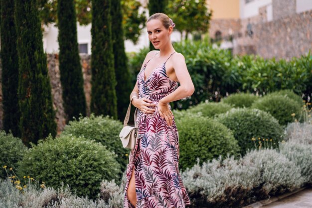 Summet trendiges Porträt einer stilvollen jungen Frau, die im Luxusurlaub posiert und ein elegantes Sommerkleid trägt