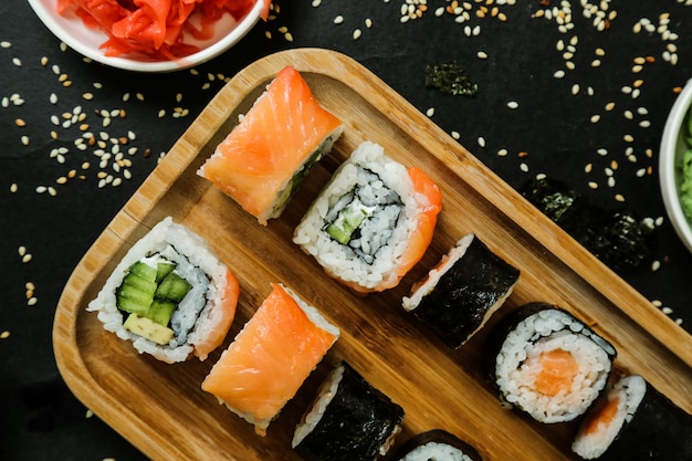 Sushi mit Gurke, Ingwer, Wasabi, Sojasauce und Sesam