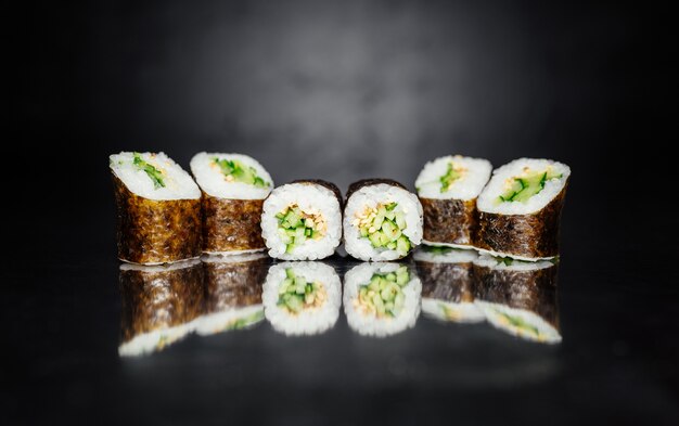 Sushi Rolle aus Nori, Marinierter Reis, Sesam weiß, Gurke. T