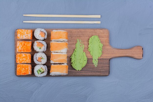 Sushi-Rollen mit Wasabi-Sauce auf einer Holzplatte