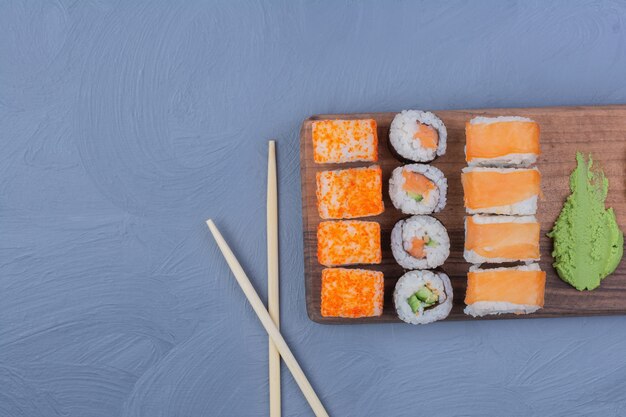 Sushi-Rollen mit Wasabi-Sauce auf einer Holzplatte