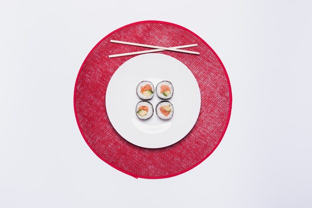 Sushi und Essstäbchen auf rotem Kreis