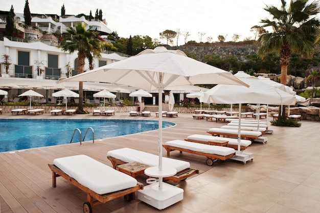 Swimmingpool mit Sonnenliegen am Morgen im mediterranen Sommerresorthotel in der Türkei Bodrum