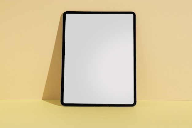 Kostenloses Foto tablet minimale anzeige mit gelbem hintergrund