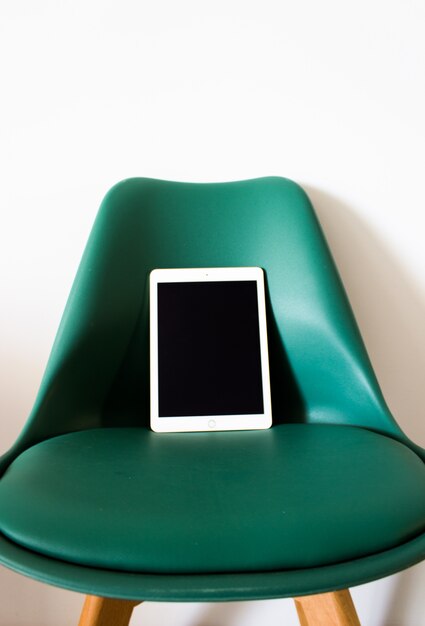 Tablet mit leeren Bildschirm auf einem Stuhl