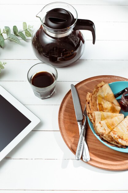 Tablette und Pfannkuchen mit Saft. Gesundes Frühstück