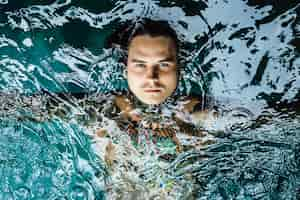 Kostenloses Foto tätowierter mann im pool im regen.