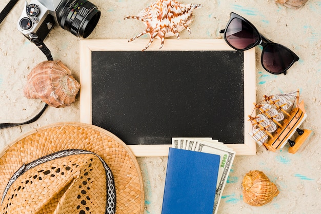 Kostenloses Foto tafel nahe hut mit spielzeugboot und -geld unter muscheln und kamera