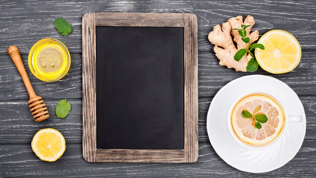 Tafel neben Tasse mit Zitronentee und Honig